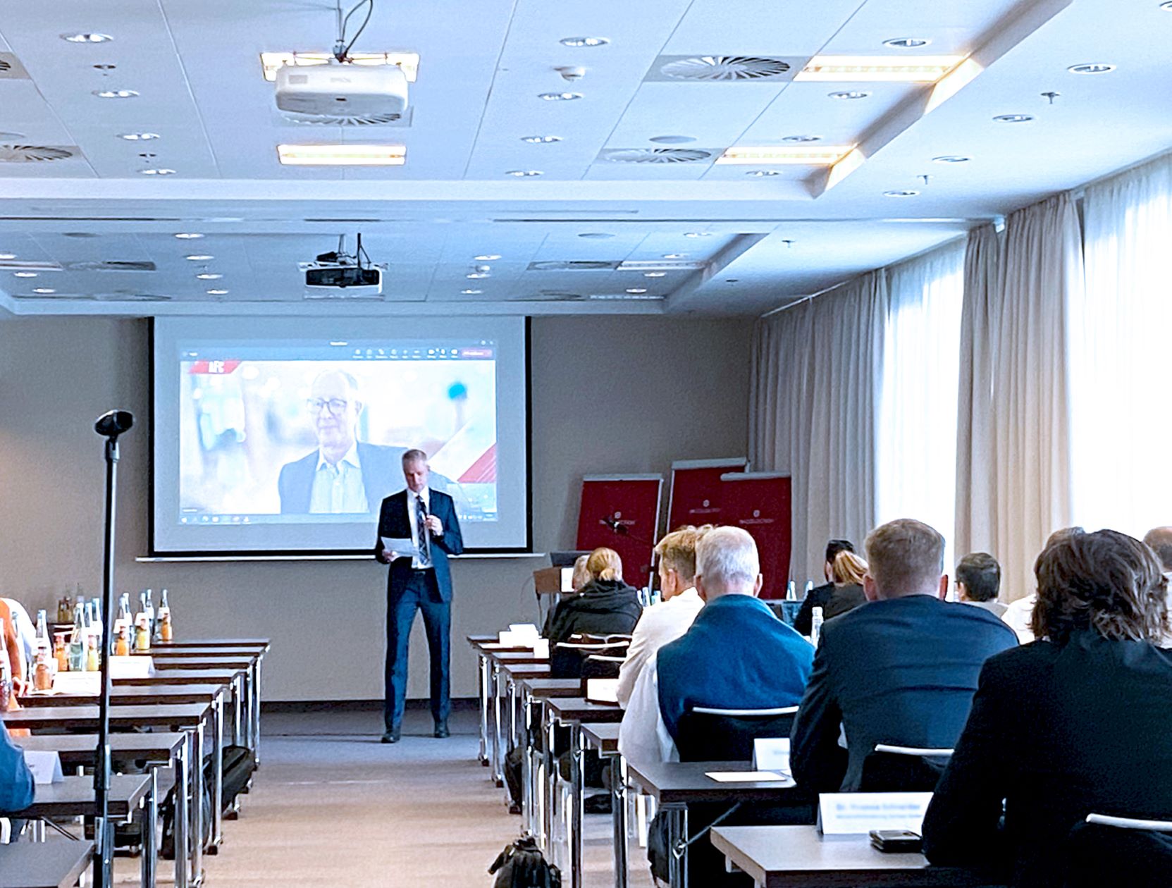 Auf dem Bild ist der Moderator der Veranstaltung, Dr. Marc Mauermann vom Fraunhofer IVV mit sitzenden Teilnehmenden vor einer Präsentationsleinwand zu sehen.
